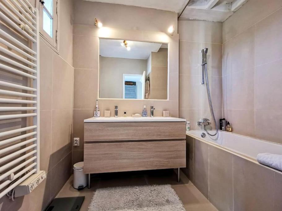 a bathroom with a sink and a tub and a mirror at Beautiful Sea View House in Vallauris
