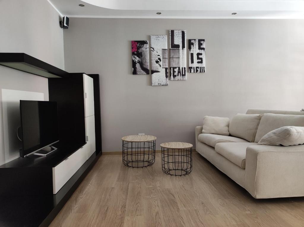 uma sala de estar com um sofá e uma televisão em qu4ttro em Riva del Garda