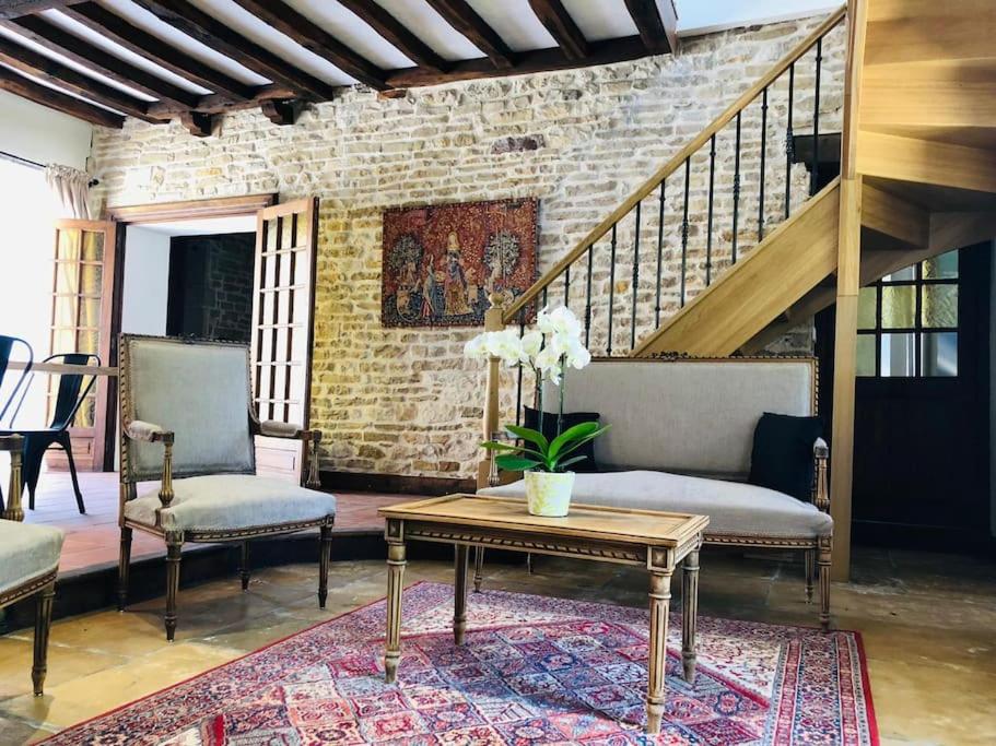 een woonkamer met 2 stoelen en een tafel bij Maison Céleste in Nuits-Saint-Georges