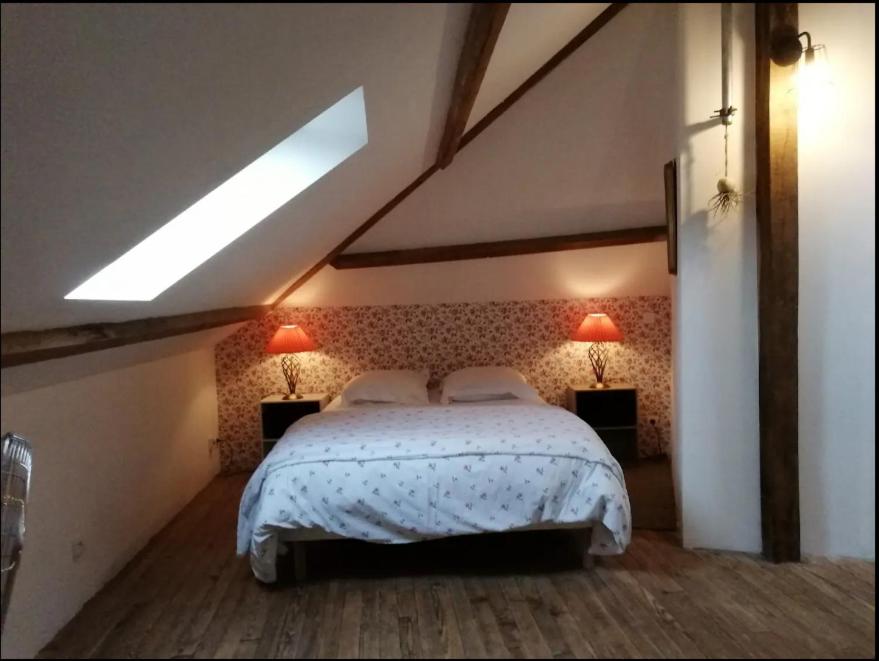 a bedroom with a bed with two lamps on it at gite du pré in Gorron