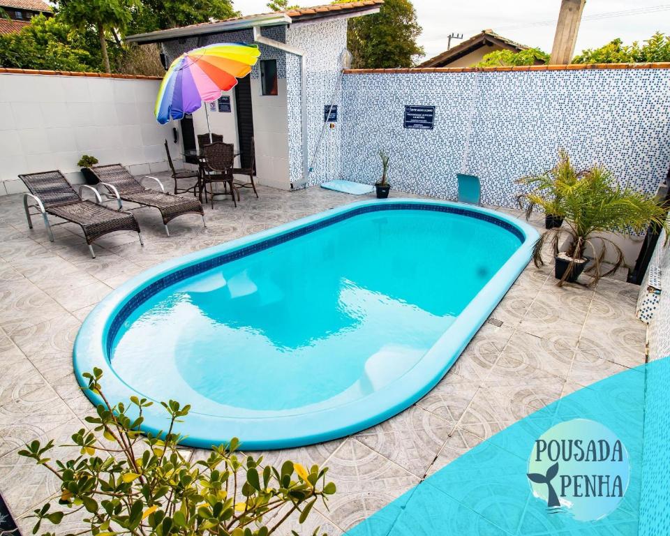 una piscina en un patio con sombrilla en Pousada Penha 1 Beto Carrero, en Penha