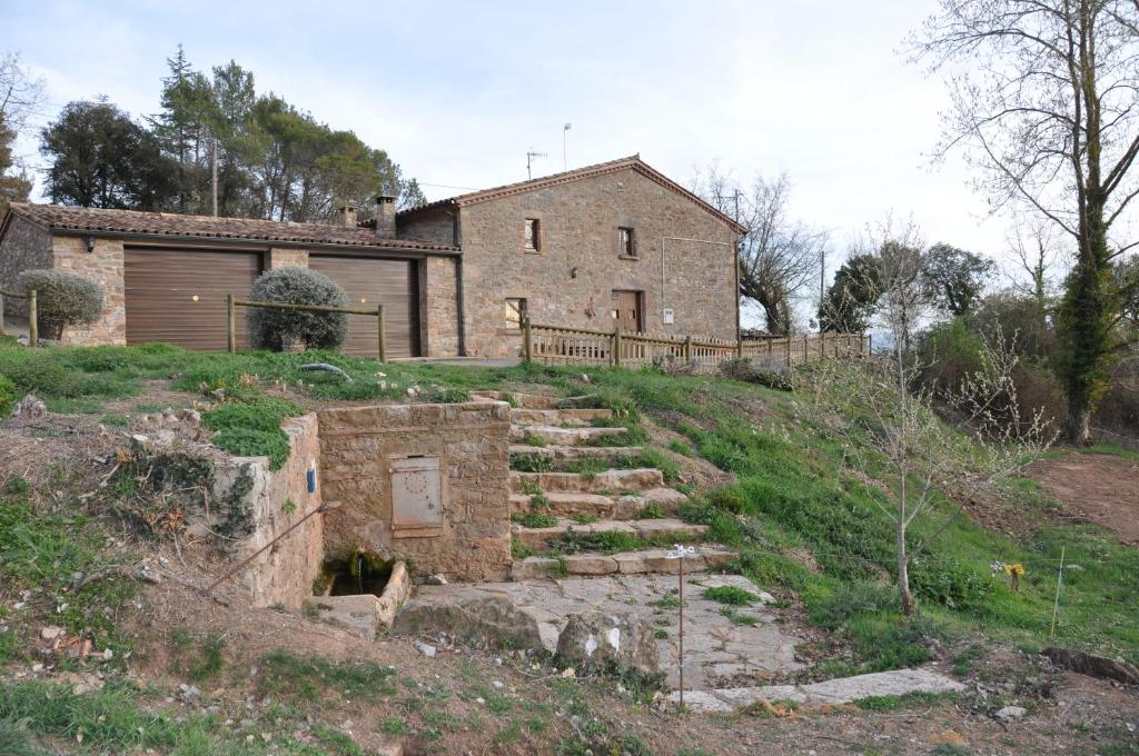 una casa antigua en una colina con una escalera de piedra en Mas Cal Gira, en Moià