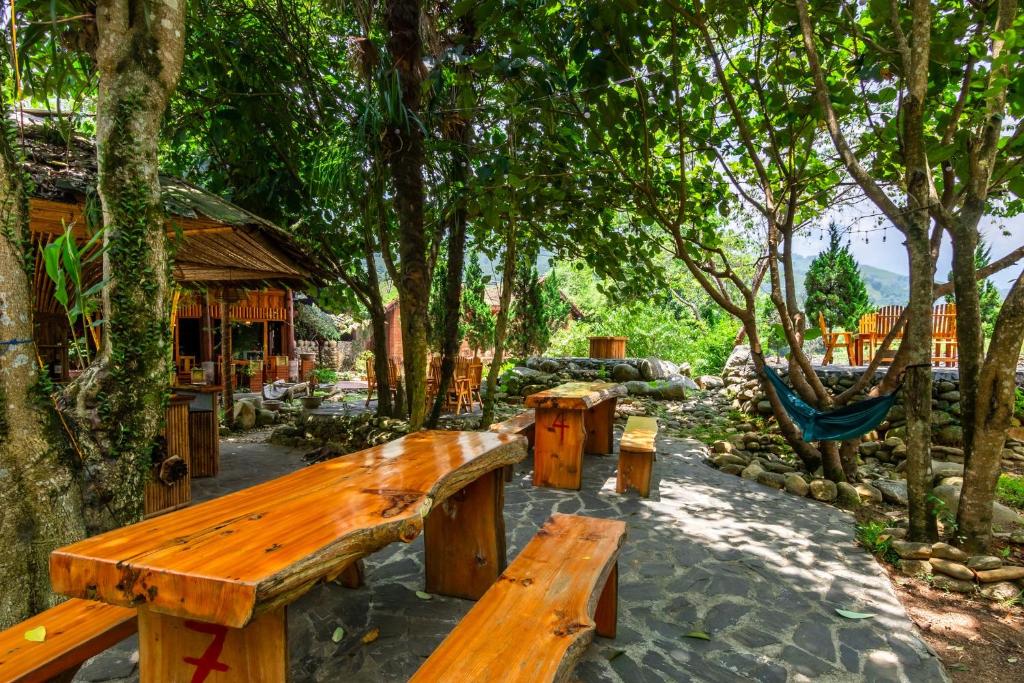 a wooden bench in a park with trees at Sapa Riverside Homestay in Sa Pa