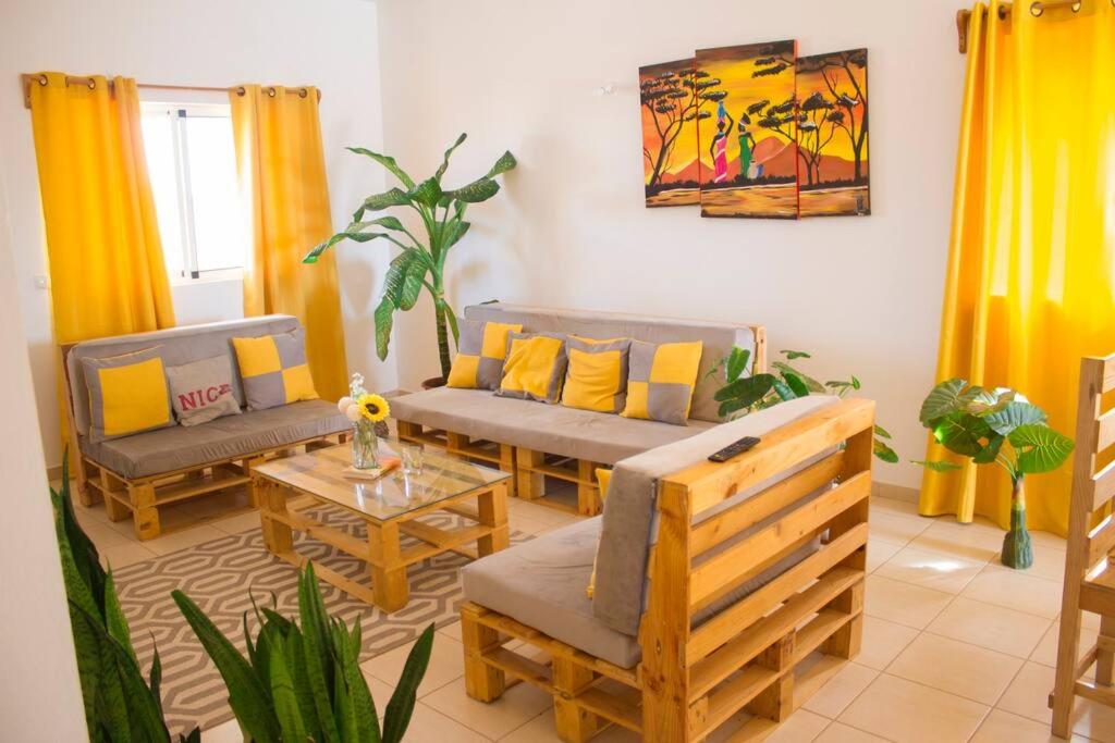 ein Wohnzimmer mit 2 Sofas und einem Tisch in der Unterkunft Cosy & Relax Yellow House 5mn walk from the beach! in Calheta Do Maio