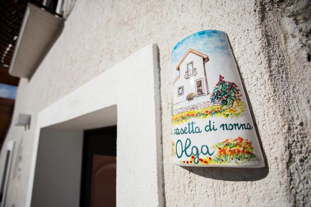 een huisbord aan de zijkant van een gebouw bij La Casetta di nonna Olga-Chalet in Agerola