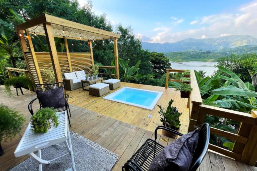 a deck with a pool and a chair and a table at Villa Exclusiva para parejas en Puerto Rico in Villalba