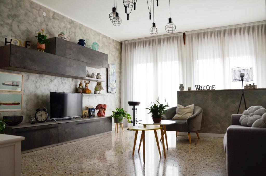 uma sala de estar com uma televisão, um sofá e uma mesa em Appartamento Ciclamino em Mestre