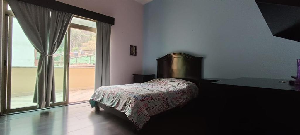 a bedroom with a bed and a large window at Cuarto Ojo de Agua in Orizaba