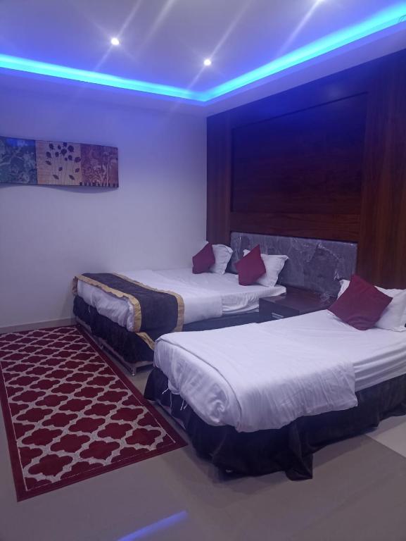 a hotel room with two beds and a blue light at برج الراية للشقق المخدومة in Riyadh