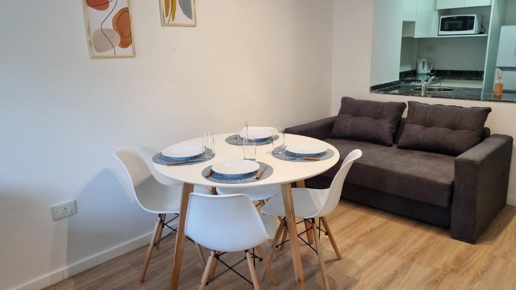 einen Tisch und Stühle im Wohnzimmer mit Sofa in der Unterkunft Lindo ambiente de Calidad ! in Rosario