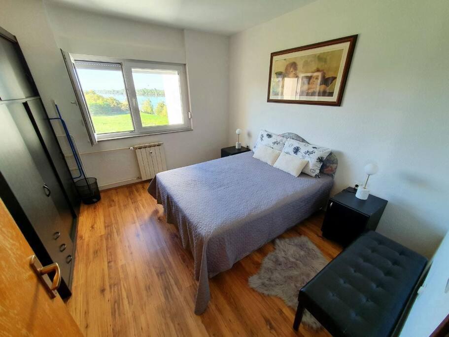 1 dormitorio con 1 cama y 1 silla en Apartman Dukat Vukovar en Vukovar