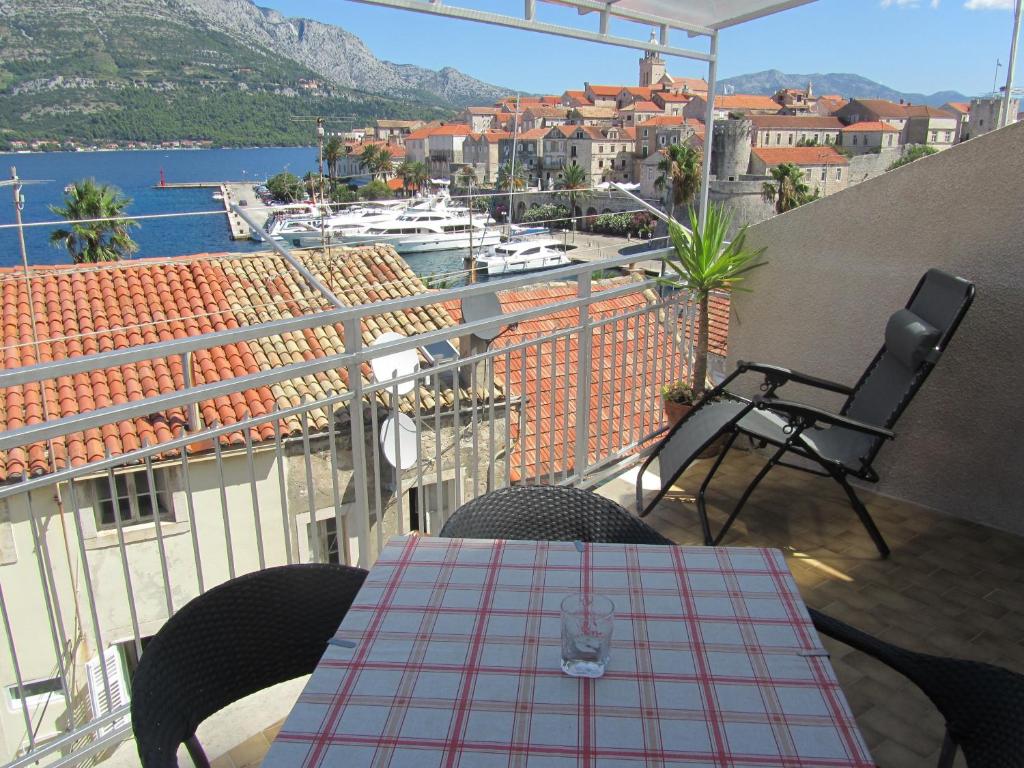 a table and chairs on a balcony with a view of a harbor at Guesthouse Franica in Korčula