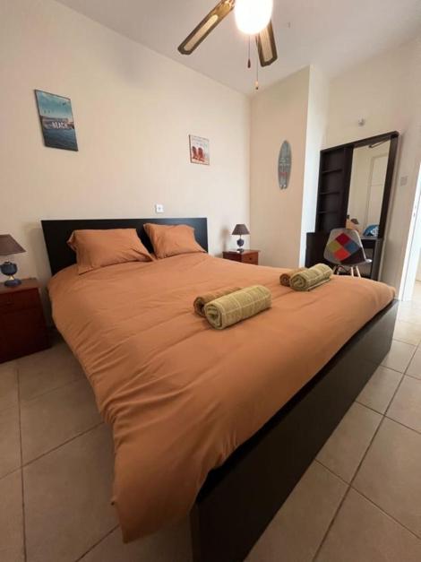ein großes Bett in einem Schlafzimmer mit zwei Handtüchern darauf in der Unterkunft The Holiday Flat, gateway to desired experiences in Peyia