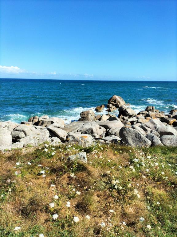 a group of rocks on the shore of the ocean at Calme et lumière à 2 pas de la mer in Plouescat