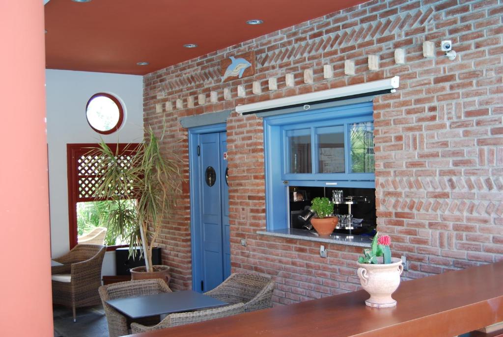a brick wall with a blue door and a table at Sirena Residence & Spa in Marathokampos
