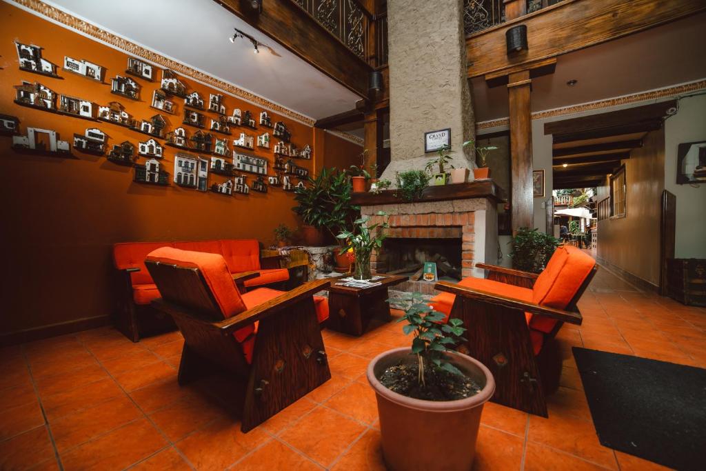 a lobby with orange chairs and a fireplace at Gran Hotel París in Cuenca