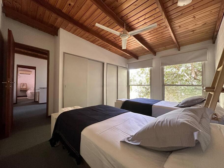 Un dormitorio con dos camas y un ventilador de techo. en Fisherton Alquiler Temporario, en Rosario