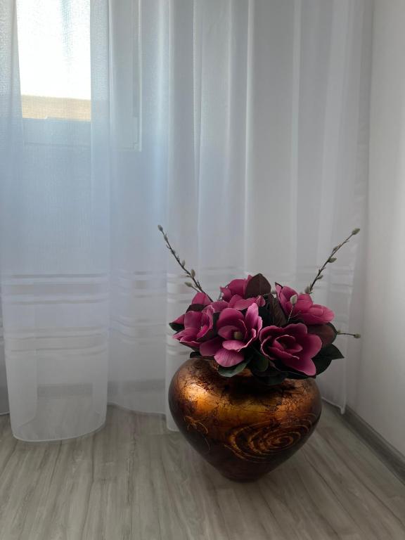 a vase with flowers in it sitting on a floor at Apartament Tudor in Oradea