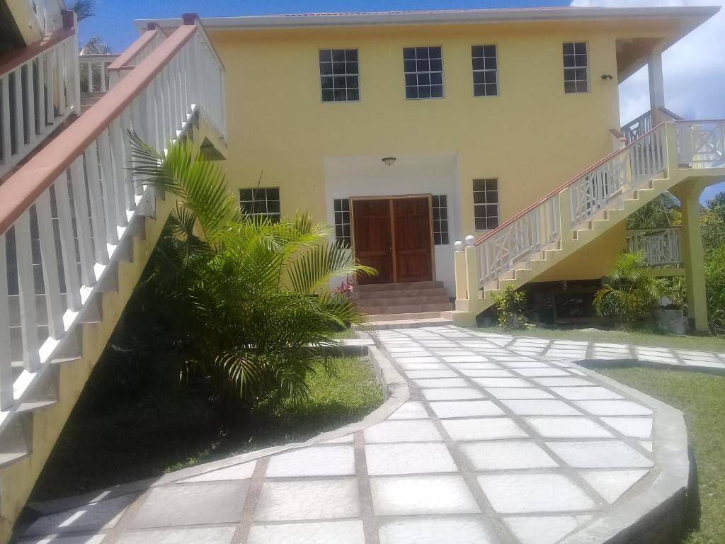 ein Haus mit einer Treppe, die zur Eingangstür führt in der Unterkunft Royal Escape in Anse La Raye