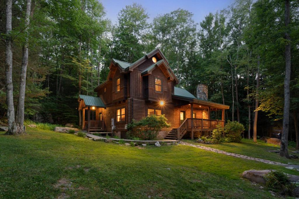 a log cabin in the woods with a green roof at Jamesons Cabin! 8 Minutes to Wisp, HotTub, FirePit, Pets, EV Chgr in Oakland