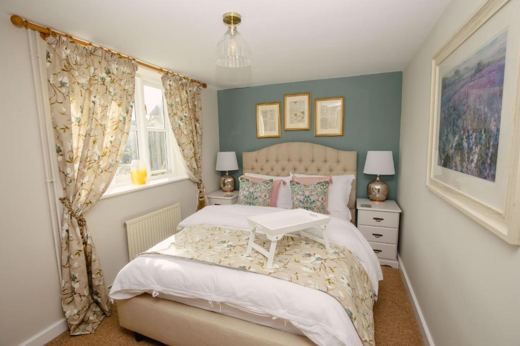 a bedroom with a bed with a table on it at Shepherds Cottage - Rudge Farm Cottages in Bridport