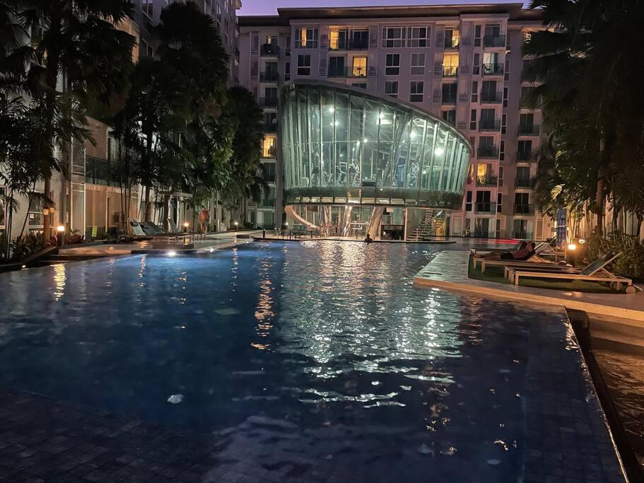 ein Schwimmbad vor einem Gebäude in der Nacht in der Unterkunft Stylish Condo with pool, sauna, steam room & gym in Pattaya