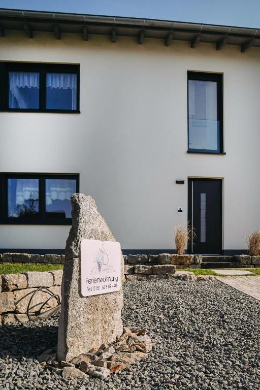 a sign in front of a white building at Ferienwohnung Im Schafftl 10 in Ramsthal