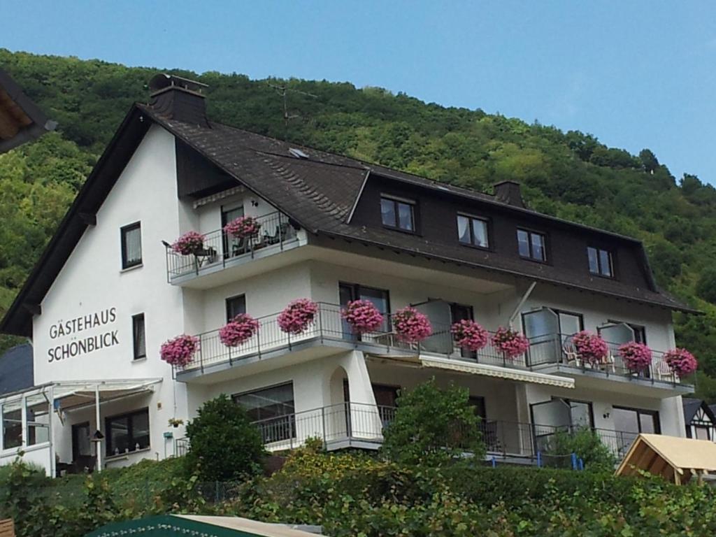 ein Gebäude mit Blumen auf den Balkonen in der Unterkunft Gästehaus Schönblick in Sankt Aldegund