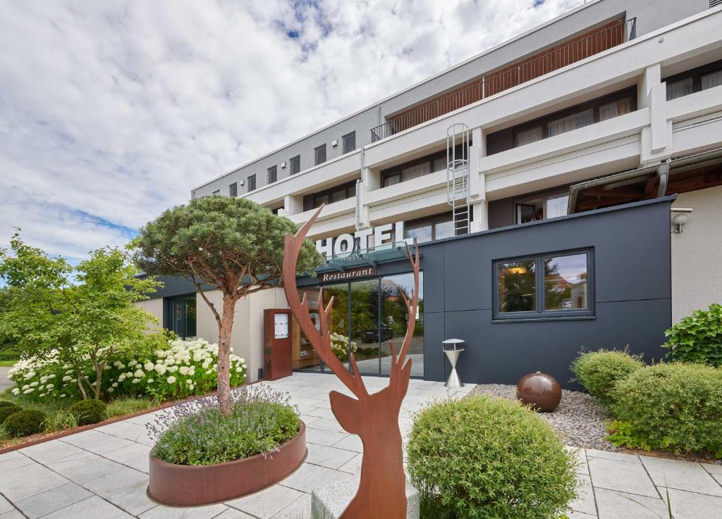 ein Hotel mit einer Statue vor einem Gebäude in der Unterkunft Hotel Schönbuch in Pliezhausen