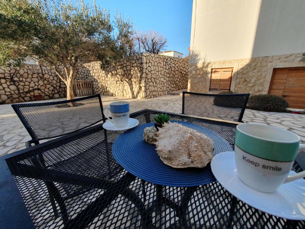 uma mesa com uma chávena de café e um bicho de peluche em Olive garden Pag studio apartment em Pag