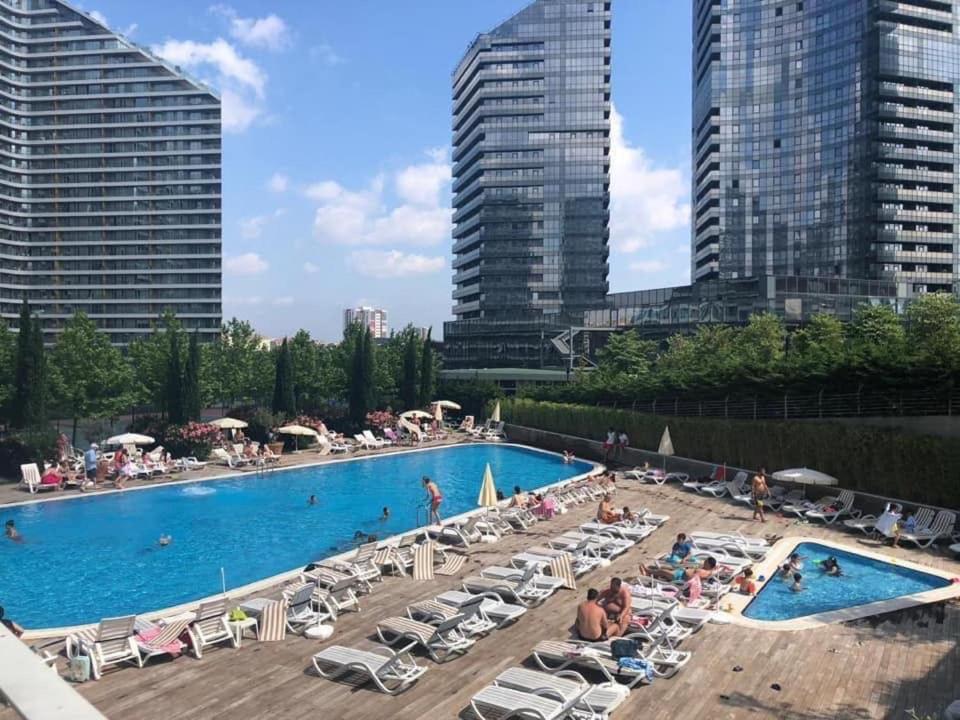 une grande piscine avec des chaises et des personnes dans une ville dans l'établissement 2-Bedroom apartment in Bati Sehir - Istanbul, à Istanbul