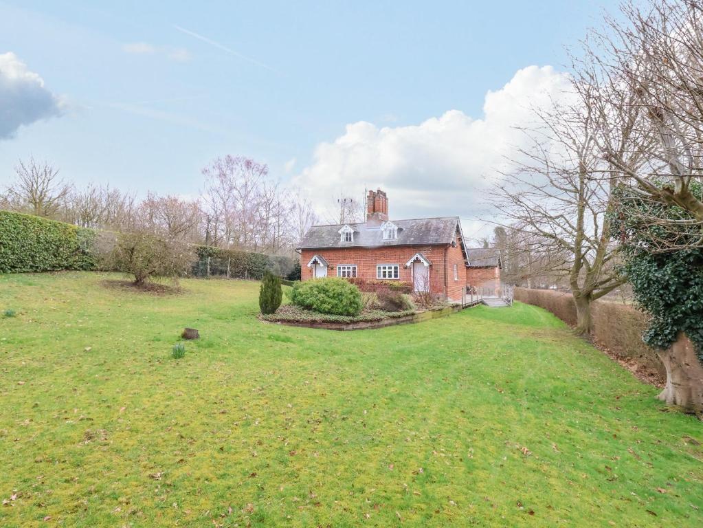 an old brick house with a large yard at Valley Farm Cottage in Woodbridge