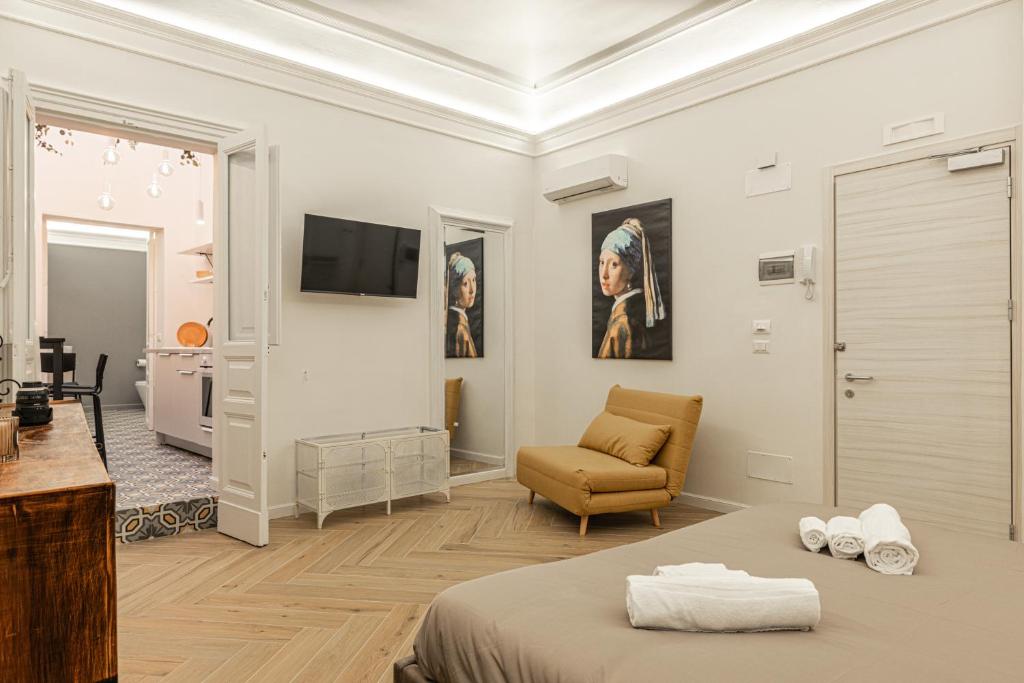 sypialnia z łóżkiem, kanapą i telewizorem w obiekcie Residenze Florio w Katanii
