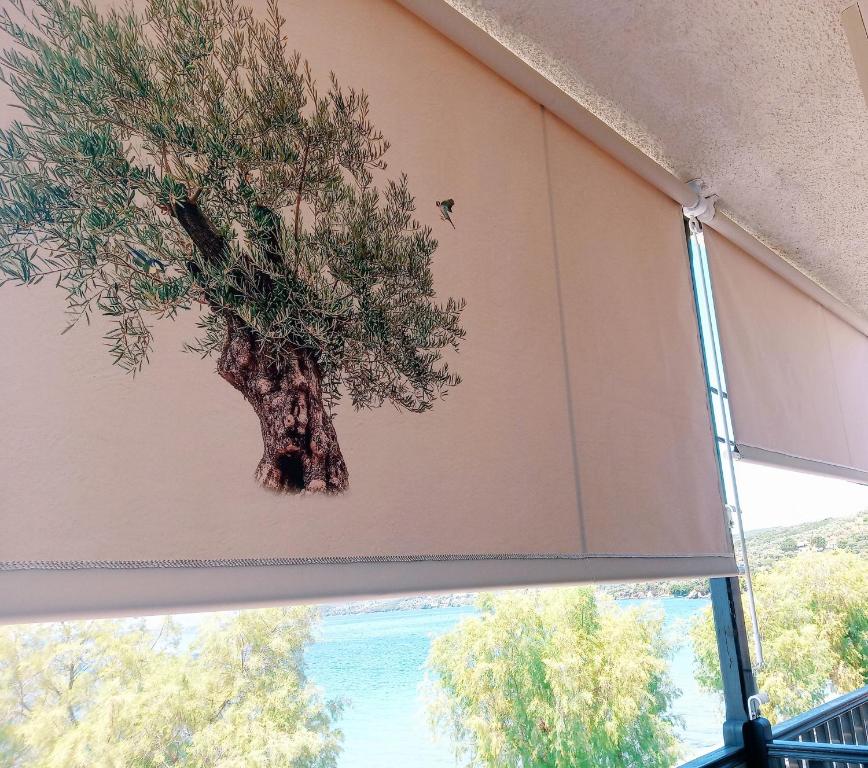 a fake tree on the wall of a window at Athina-Milina in Milína