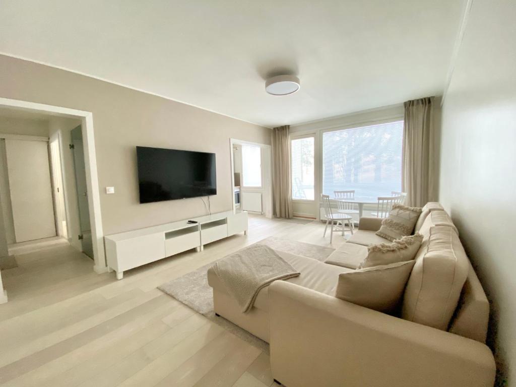 Il comprend un salon doté d'un canapé et d'une télévision à écran plat. dans l'établissement City Apartment Sotilaskatu, à Iisalmi