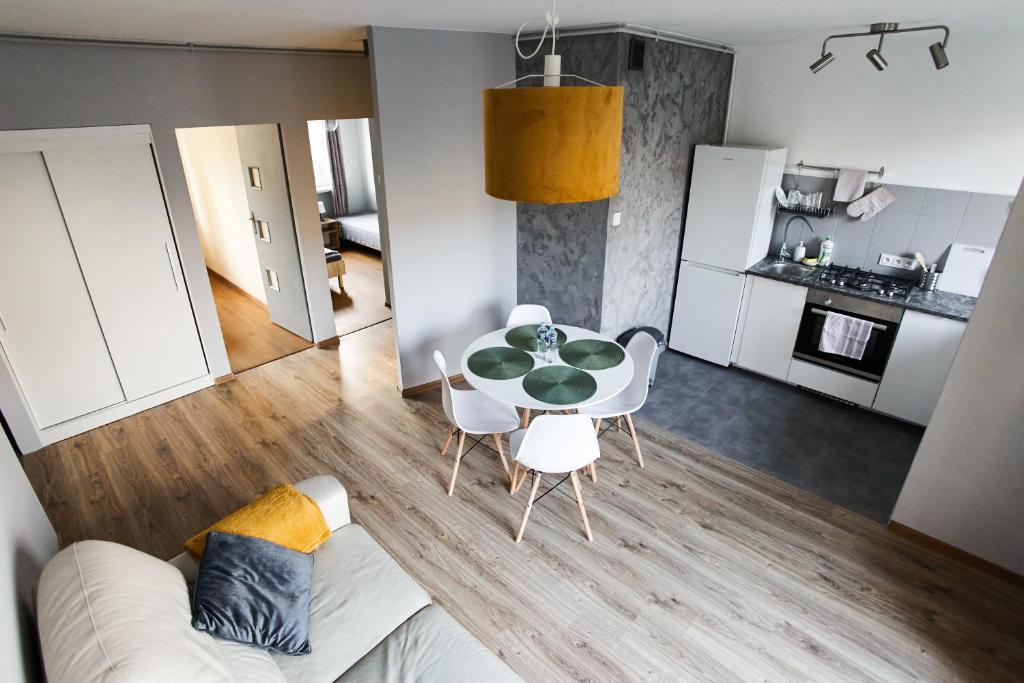 a living room with a table and chairs and a kitchen at Grójecka Apartament in Warsaw