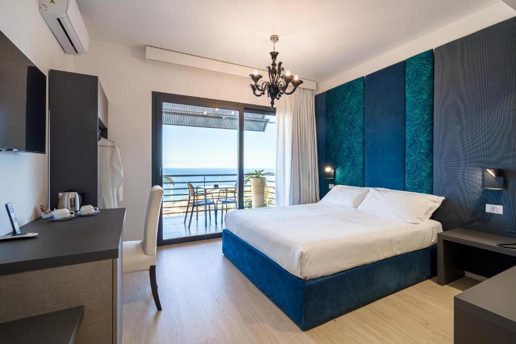 タオルミーナにあるタオルミナ パレス ホテルのベッド付きのホテルルームで、海の景色を望めます。