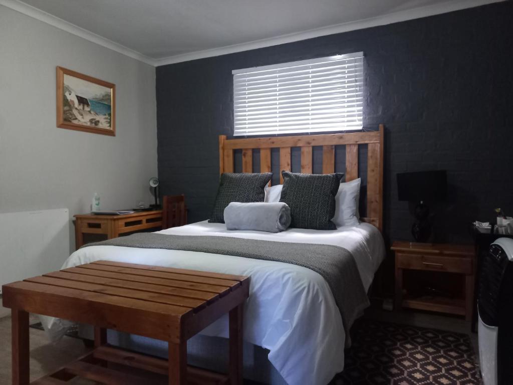a bedroom with a large bed with a wooden headboard at 13 on 2nd Hermanus in Hermanus