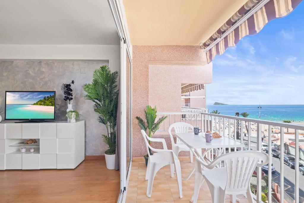 uma varanda com uma mesa e cadeiras e o oceano em Los Ranchos 4-3 Apartment Levante Beach em Benidorm
