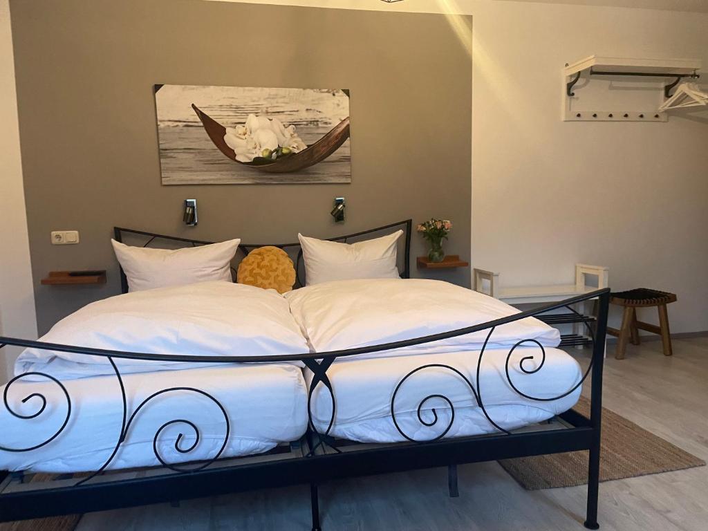 ein Bett mit weißer Bettwäsche und ein Gemälde an der Wand in der Unterkunft Hotel-Gasthof Grüner Hof in Freising