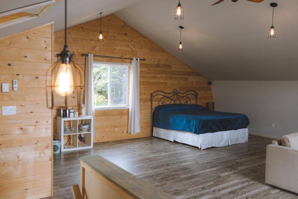 um quarto com uma cama num quarto com paredes de madeira em By the Bay Lavender Villa em Chemainus