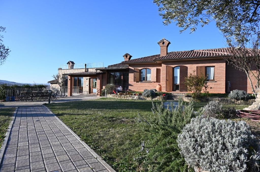 uma casa de tijolos com um caminho à sua frente em Agriturismo A Casa Mia Gubbio em Gubbio