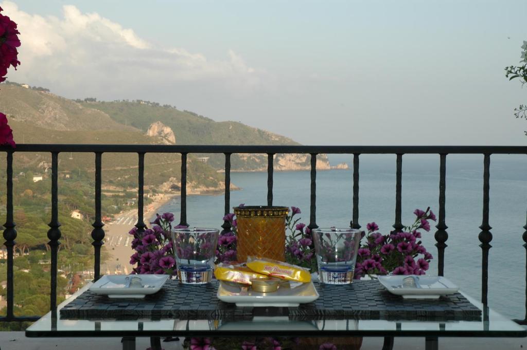 a table with food and glasses on a balcony at Hotel Corallo Sperlonga in Sperlonga