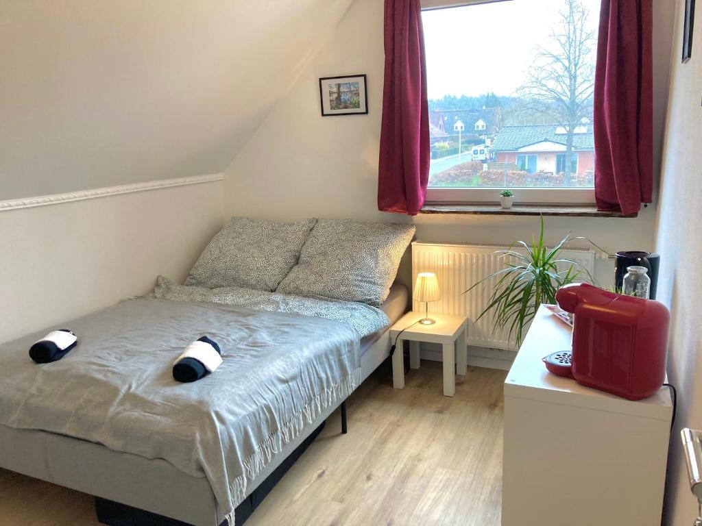 ein kleines Schlafzimmer mit einem Bett und einem Fenster in der Unterkunft Casa Hasselholt in Ratzeburg