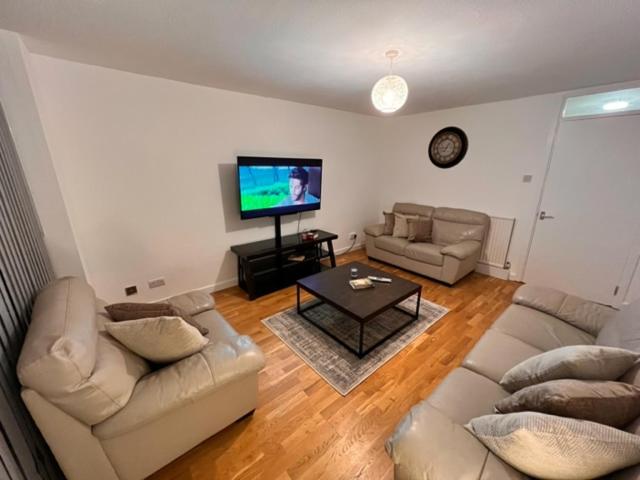 uma sala de estar com 2 sofás e uma televisão de ecrã plano em Archway Islington London em Londres