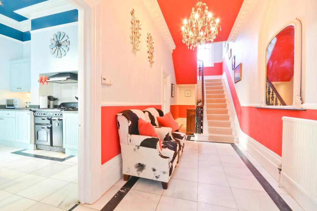 una sala de estar con paredes rojas y una silla en Clevelands Country House Holiday Rental 10 Guests en Wroxall