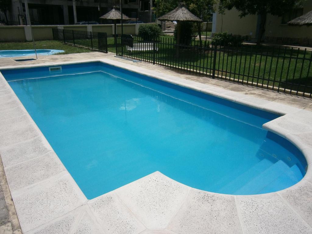 a large blue swimming pool in a yard at Hotel Nuevo Fatica in Villa Carlos Paz