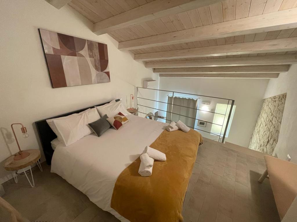 sypialnia z dużym białym łóżkiem z ręcznikami w obiekcie Casa Shekelesh w mieście Scicli