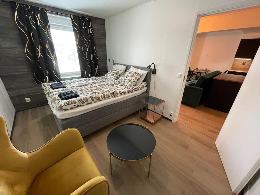 een slaapkamer met een bed, een bank en een stoel bij The Park House Suite, Jakobstad in Pietarsaari