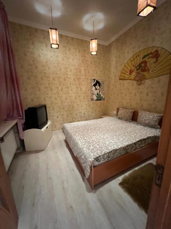 1 dormitorio con 1 cama y TV de pantalla plana en 10 Kotliarska Moisha House, en Leópolis